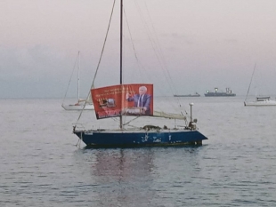 A banner protesting the Australia Government in support of Witness K and Bernard Collaery unfolded on a yacht  in front of the Palacio do Governo